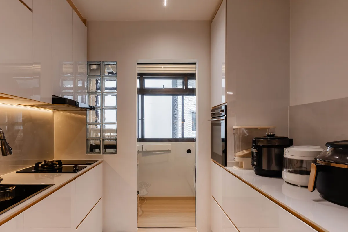White kitchen with glass block screen and warm under-cabinet lighting at Fernvale St